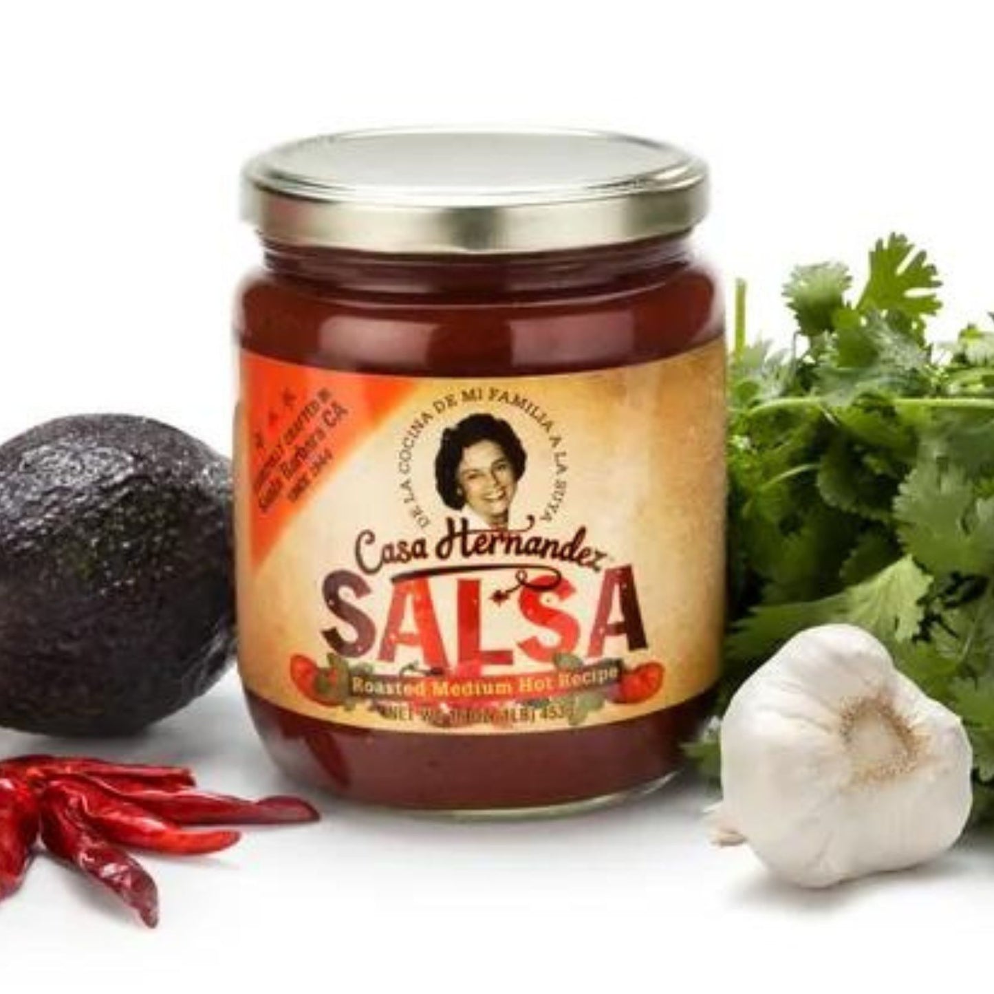 A jar of Casa Hernandez Salsa with a clear visual of the product label, which includes a picture of a woman, surrounded by ingredients like avocado, cilantro, lime, and chili peppers. Family owned by a local Santa Barbara family.