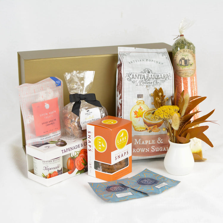 Cozy fall gratitude gift box with artisan popcorn, spiced apple treats, tapenade, ginger snaps, lentil curry soup mix, and dried floral arrangement