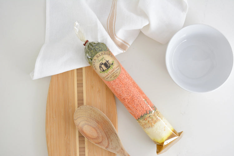 Santa Barbara Soup Coconut Lentil Curry dry mix on wooden board with wooden spoon and white bowl