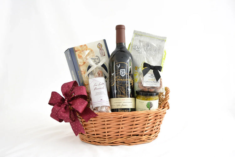 Wicker gift basket with Grassini Cabernet Sauvignon wine, crackers, sea salt caramels, candied pecans, and jarred spread